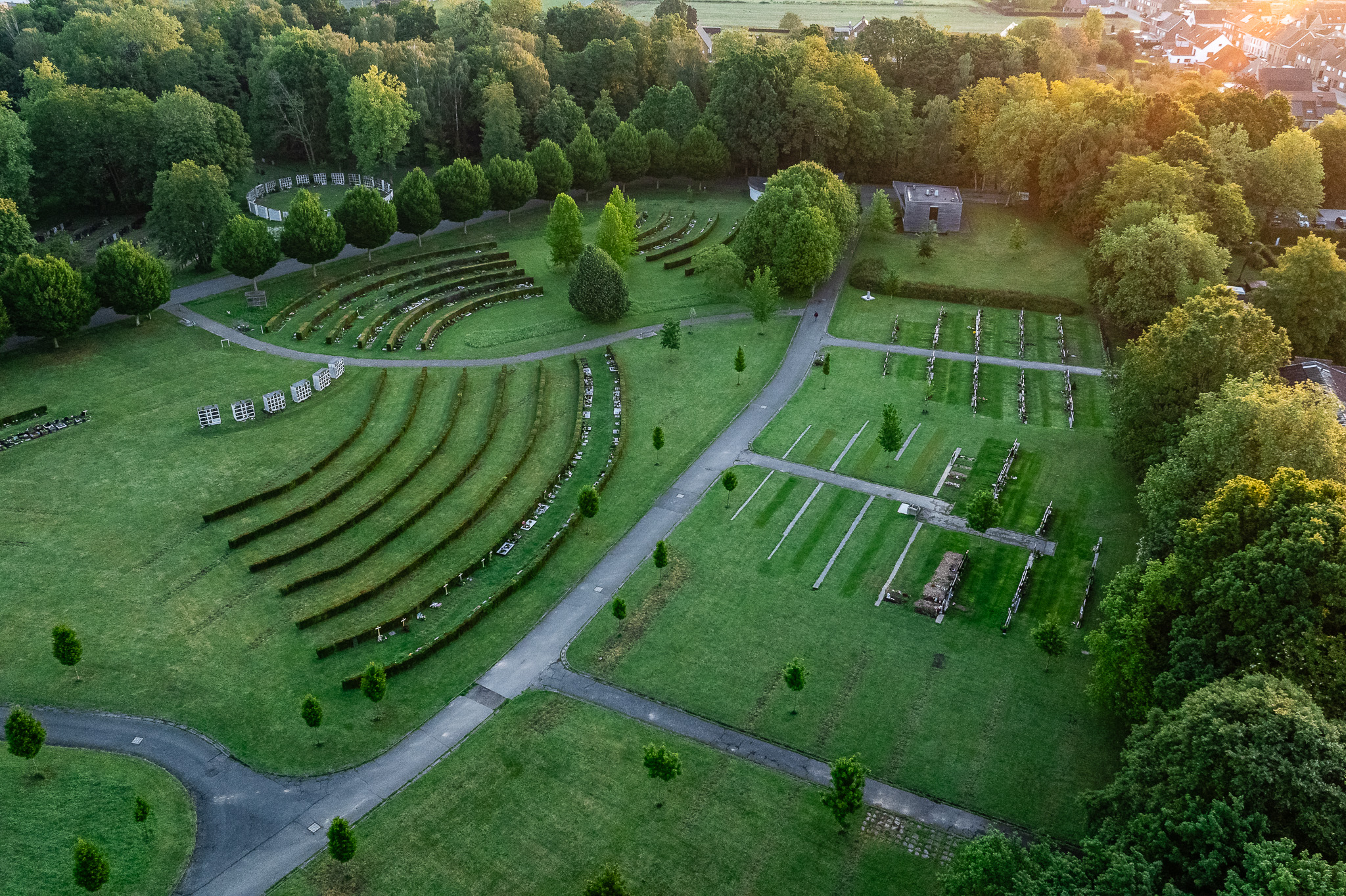Dronefoto van de landschappelijke inrichting van de begraafplaats Meulewal in Oudenaarde tijdens het gouden uur.