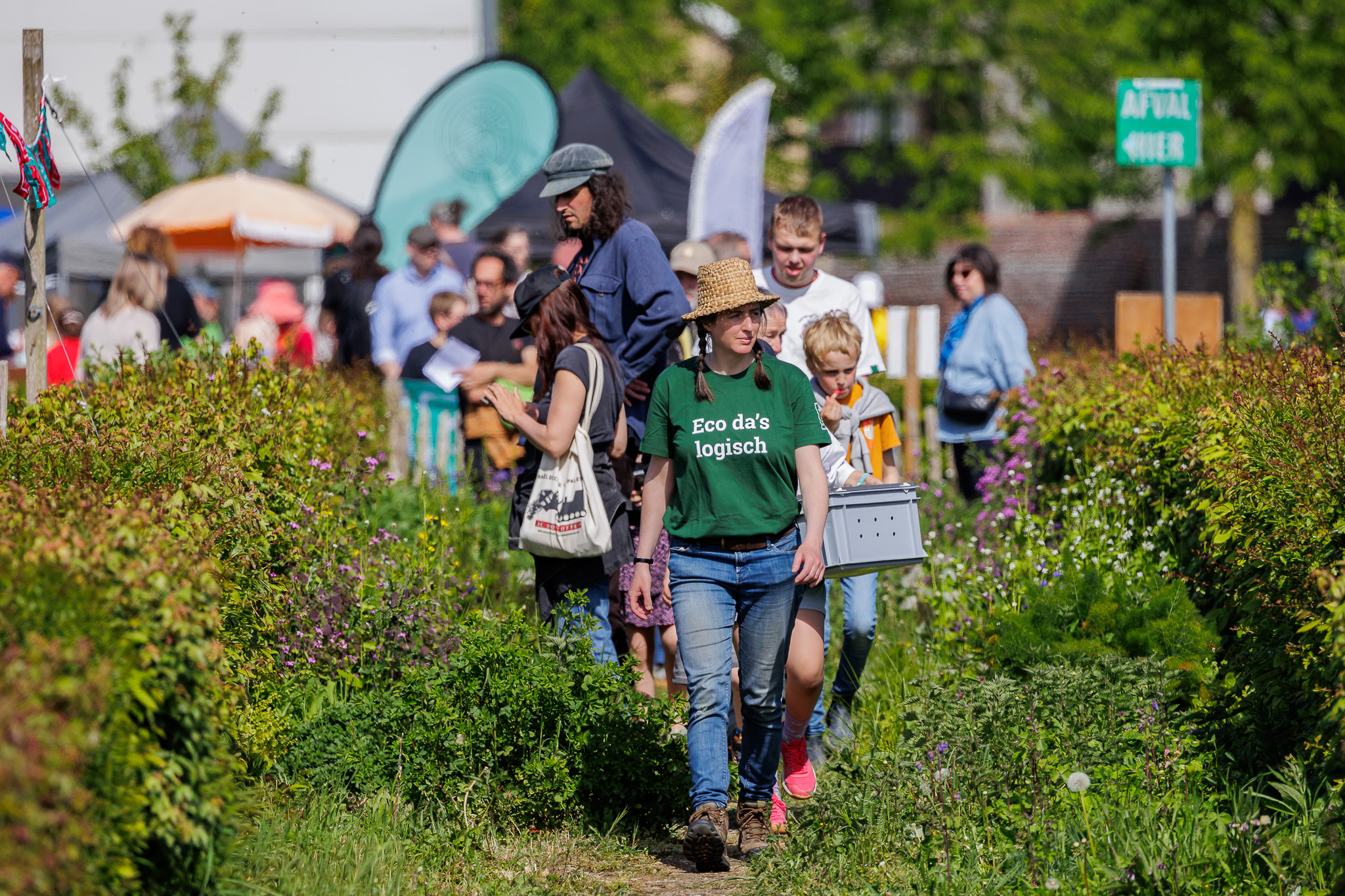 Bezoekers wandelen door de natuurtuinen in het Archeopark onder begeleiding van een gids